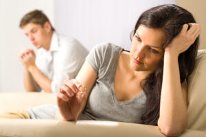 sad wife looking at her ring after fight with husband