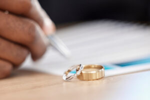 Divorce, rings and signature on paperwork for a lawyer